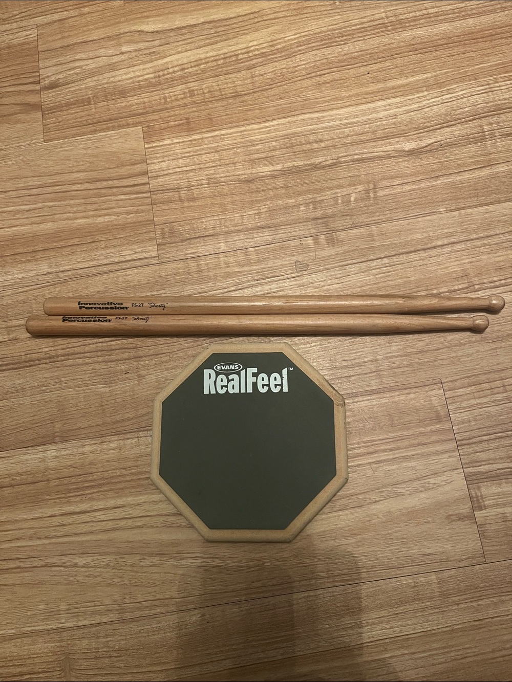 Evans RealFeel Practice Pad in Black with Natural Wood Rim and Drumsticks